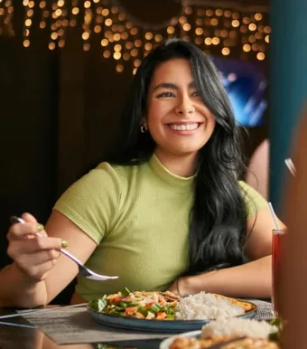 Clienta sonriendo mientras almuerza en Green Life