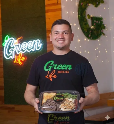 Integrante de Green Life sosteniendo una bandeja de comida empacada