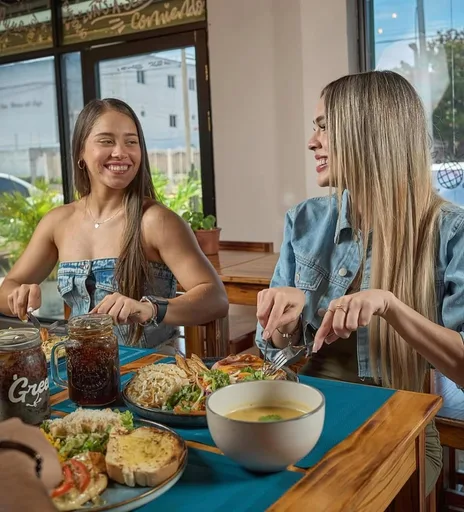 Dos amigas comiendo y conversando en Green Life