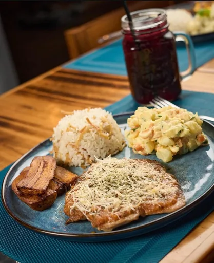 Milanesa gratinada con arroz, ensalada de papa y tajadas